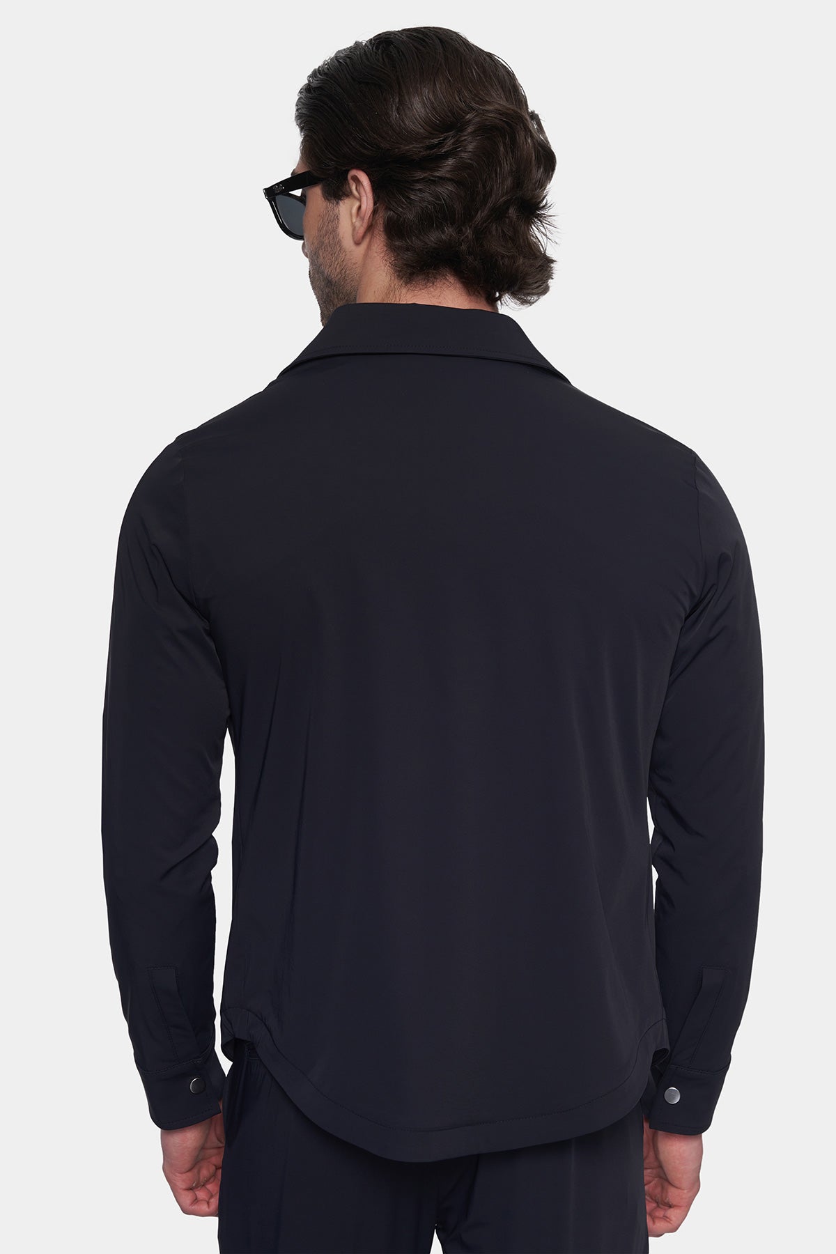 Man wearing a black shirt from behind on a white background