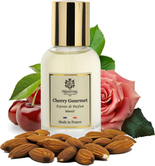 Luxury cherry perfume bottle next to cherry, almond, and rose, made in France, elegant scent for all.