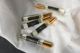 Set of small perfume bottles labeled with numbers on a white fabric background