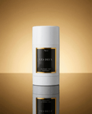 White cylindrical deodorant container with 'Les Deux' branding on a gold gradient background