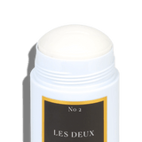 White deodorant stick with a black label on a green background