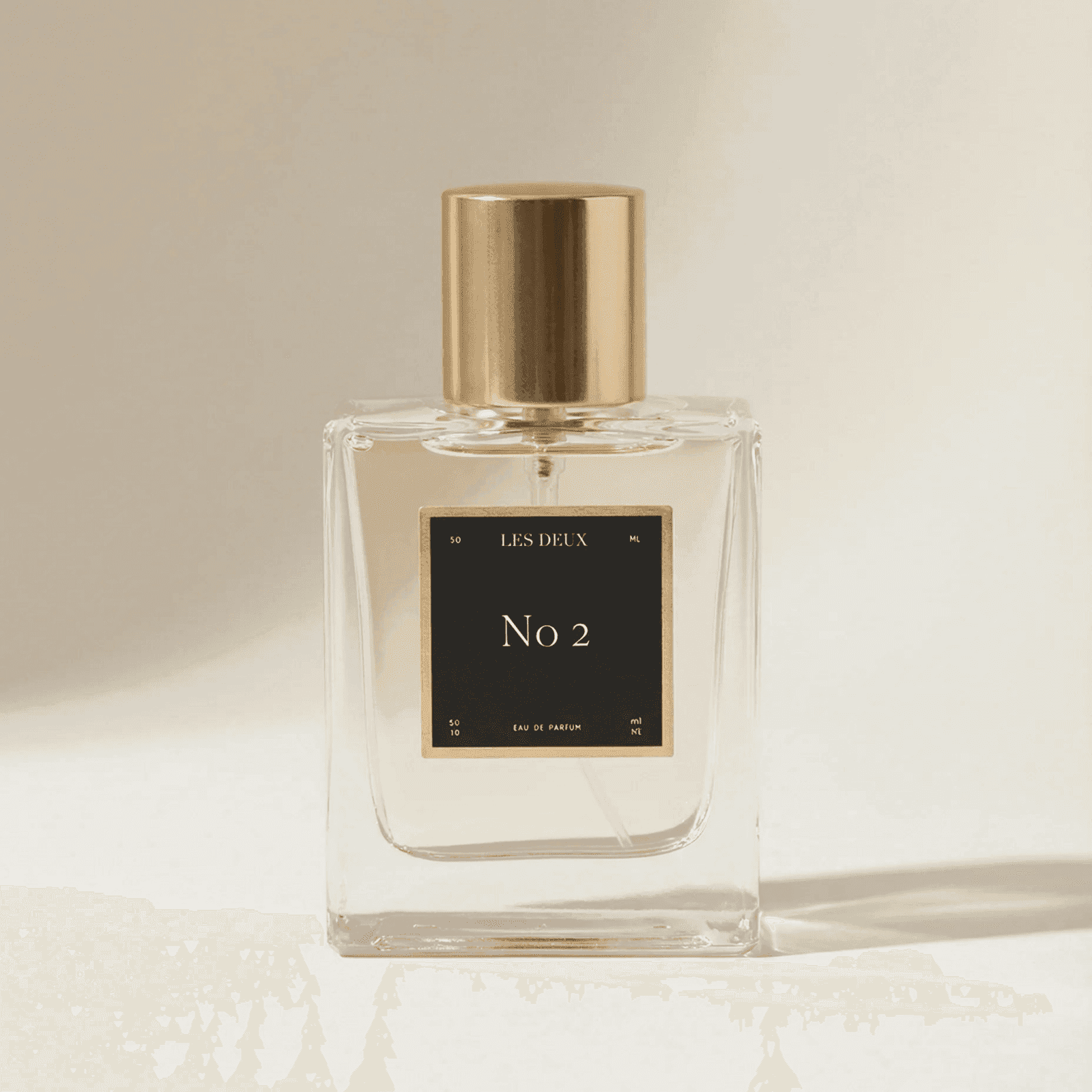 Perfume bottle labeled 'No 2' by 'Les Deux' on a beige background