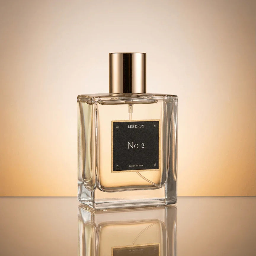 Perfume bottle labeled 'No 2' on a reflective surface with a gradient background