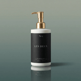White bottle with gold pump and black label on a green background