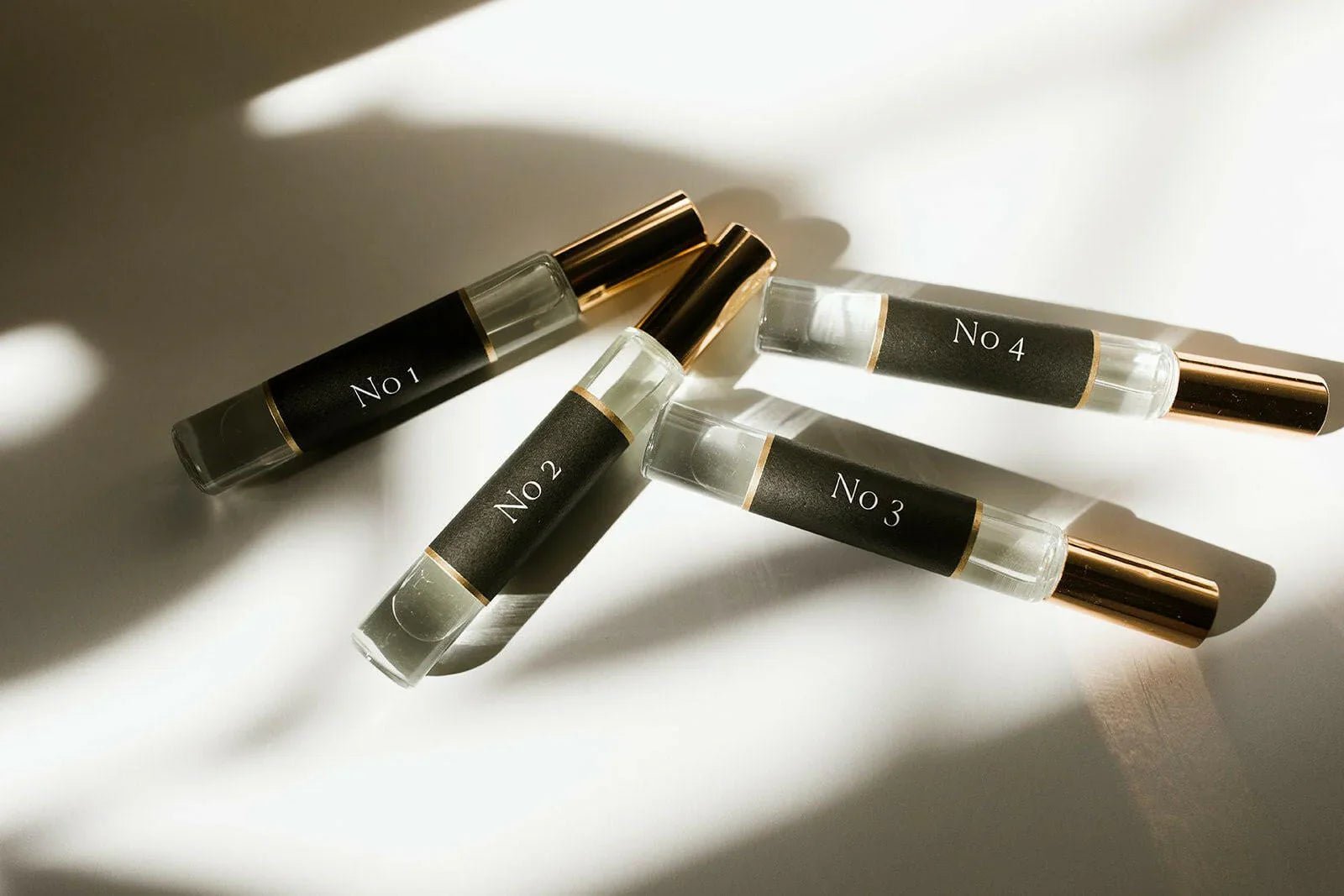 Five small glass bottles with metallic caps labeled 'No. 1' to 'No. 5' on a light background.