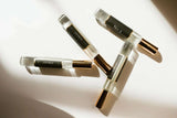 Set of clear perfume bottles with black labels on a light background