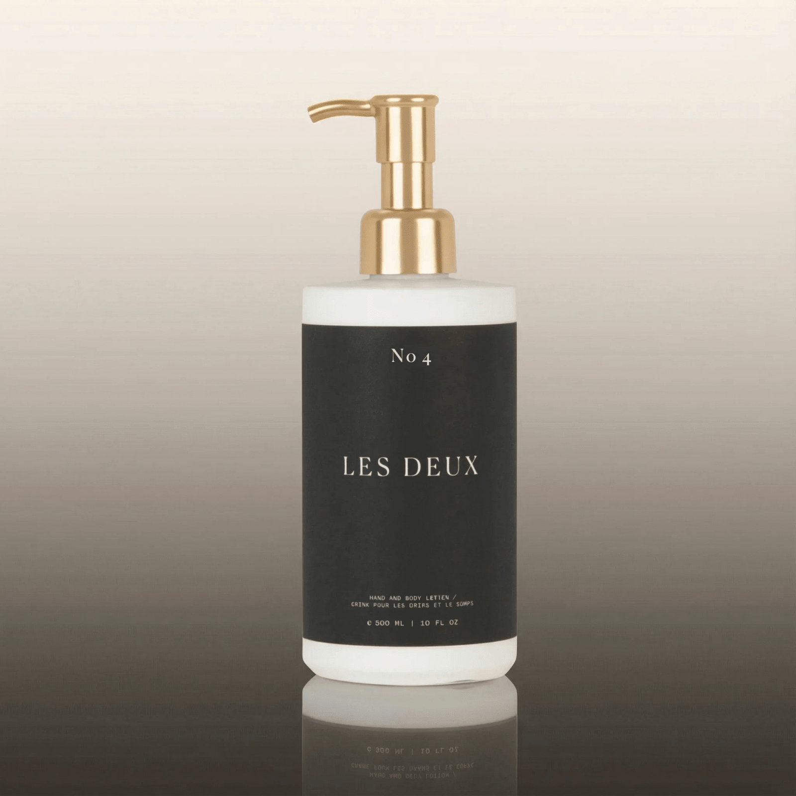 Bottle of 'Les Deux' with a gold pump on a gradient background