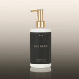 Bottle of 'Les Deux' with a gold pump on a gradient background
