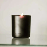 Black candle in a container with 'LES DEUX' branding on a light gray background