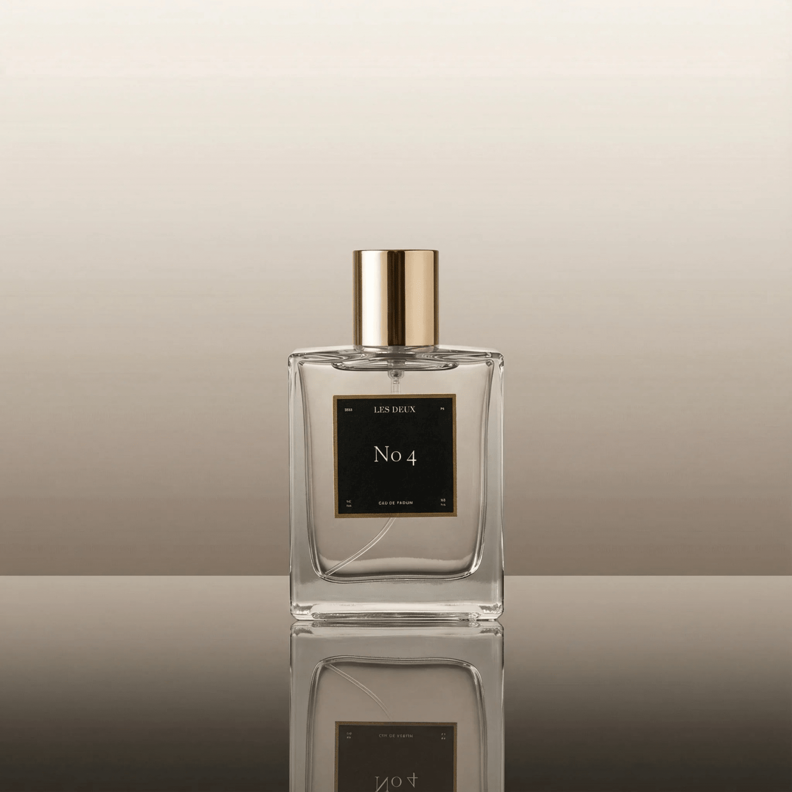 Perfume bottle labeled 'No. 4' by 'Les Deux' on a reflective surface with a neutral background