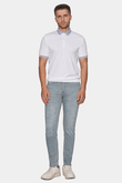 Man wearing a white polo shirt and light gray pants on a white background