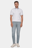 Man wearing a white polo shirt and light gray pants on a white background