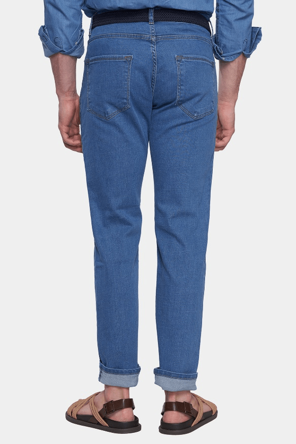 Person wearing blue jeans on a white background