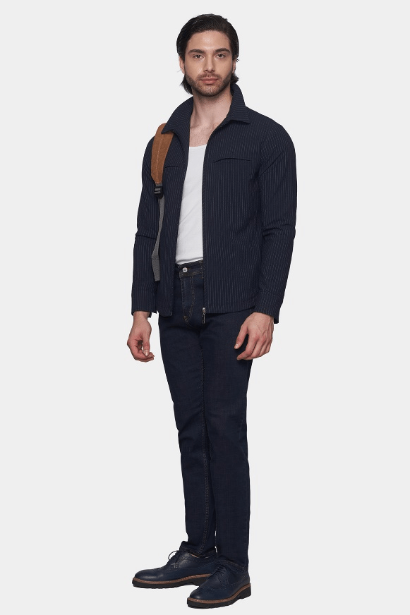 Man wearing a dark blue jacket, white shirt, and black pants on a white background