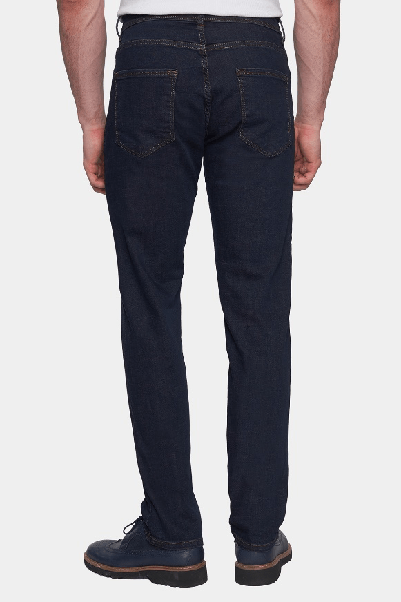 Person wearing dark blue jeans on a white background