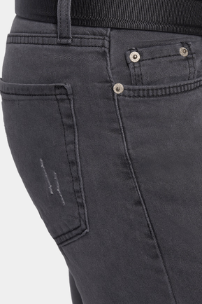 Close-up of dark gray jeans with button details on a light gray background
